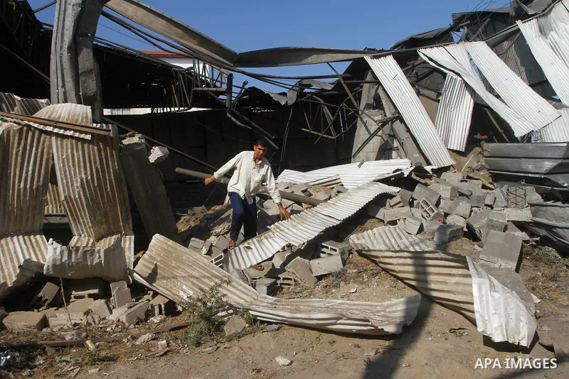 Palestinians inspect the rubble of a metal workshop after an Israeli air strike in Gaza city, early Thursday, July 14, 2011. Photo by Ashraf Amra