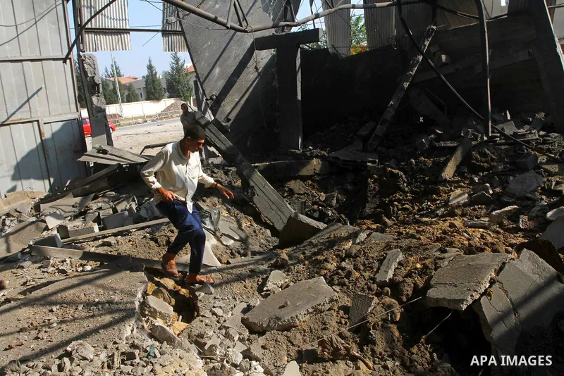 Palestinians inspect the rubble of a metal workshop after an Israeli air strike in Gaza city, early Thursday, July 14, 2011. Photo by Ashraf Amra