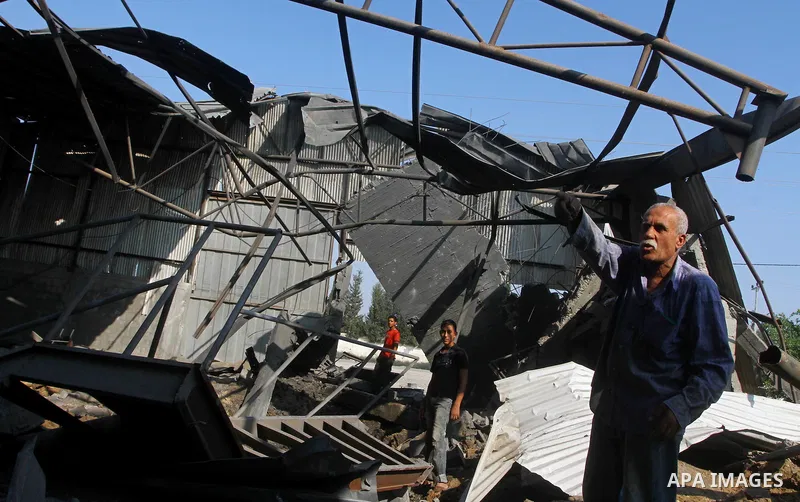 Palestinians inspect the rubble of a metal workshop after an Israeli air strike in Gaza city, early Thursday, July 14, 2011. Photo by Ashraf Amra