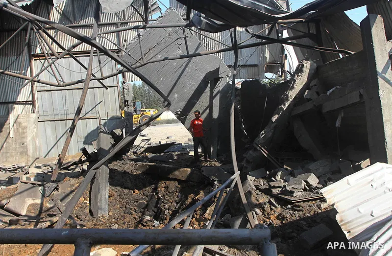 Palestinians inspect the rubble of a metal workshop after an Israeli air strike in Gaza city, early Thursday, July 14, 2011. Photo by Ashraf Amra