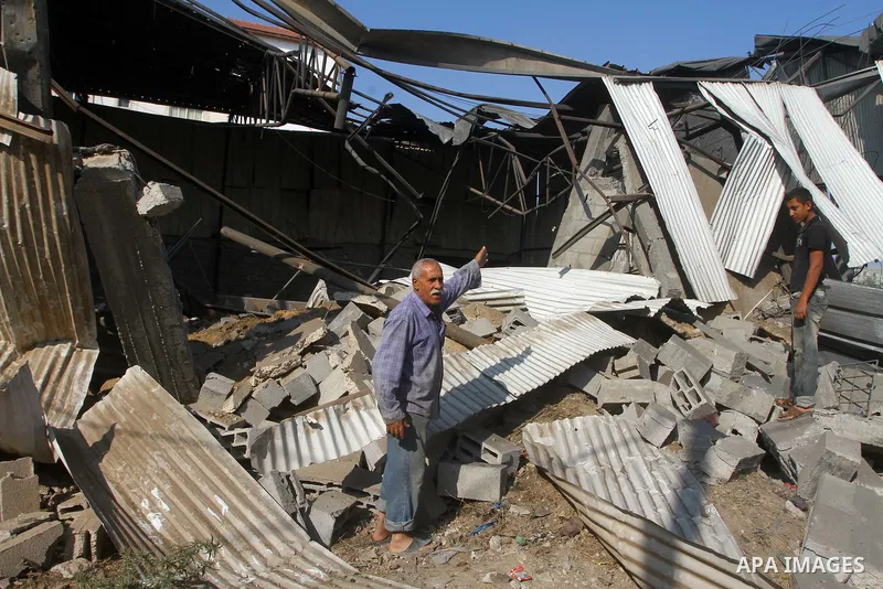 Palestinians inspect the rubble of a metal workshop after an Israeli air strike in Gaza city, early Thursday, July 14, 2011. Photo by Ashraf Amra
