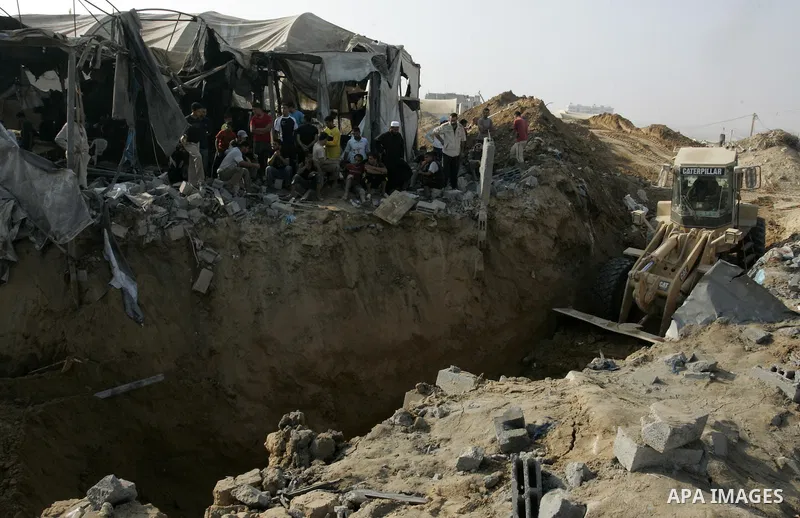 Palestinians inspect the site of a smuggling tunnel between the Gaza Strip and Egypt after it was targeted by an Israeli air strike overnight in Rafah, in the southern enclaved Palestinian territory, on July 14, 2011. Ph...