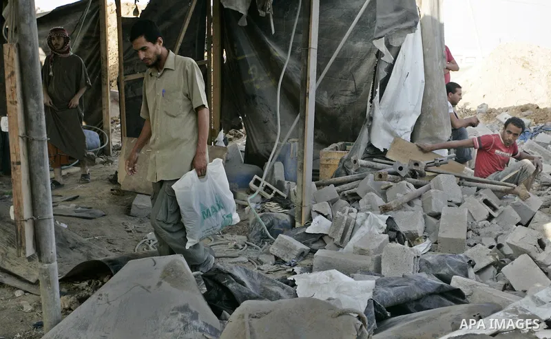 Palestinians inspect the site of a smuggling tunnel between the Gaza Strip and Egypt after it was targeted by an Israeli air strike overnight in Rafah, in the southern enclaved Palestinian territory, on July 14, 2011. Ph...