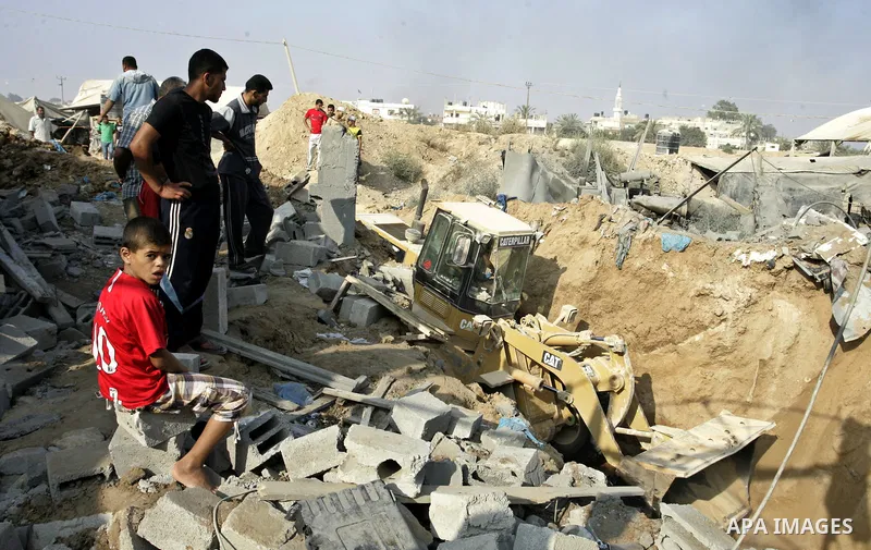 Palestinians inspect the site of a smuggling tunnel between the Gaza Strip and Egypt after it was targeted by an Israeli air strike overnight in Rafah, in the southern enclaved Palestinian territory, on July 14, 2011. Ph...