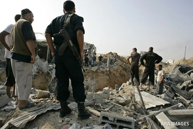 Palestinians inspect the site of a smuggling tunnel between the Gaza Strip and Egypt after it was targeted by an Israeli air strike overnight in Rafah, in the southern enclaved Palestinian territory, on July 14, 2011. Ph...