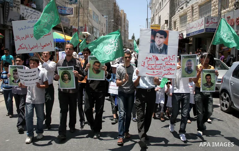Hamas members of the Palestinian Legislative Council (PLC) take part with Palestinian supporters of the Hamas Islamist movement during a rally calling for the release of Palestinians being held in West Bank and Gaza Stri...