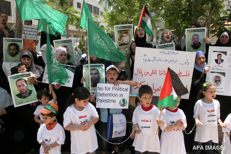 Hamas members of the Palestinian Legislative Council (PLC) take part with Palestinian supporters of the Hamas Islamist movement during a rally calling for the release of Palestinians being held in West Bank and Gaza Stri...
