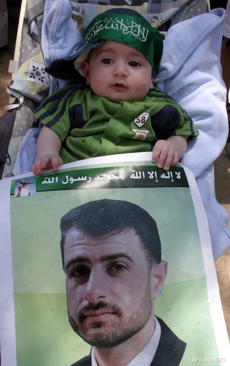 Hamas members of the Palestinian Legislative Council (PLC) take part with Palestinian supporters of the Hamas Islamist movement during a rally calling for the release of Palestinians being held in West Bank and Gaza Stri...