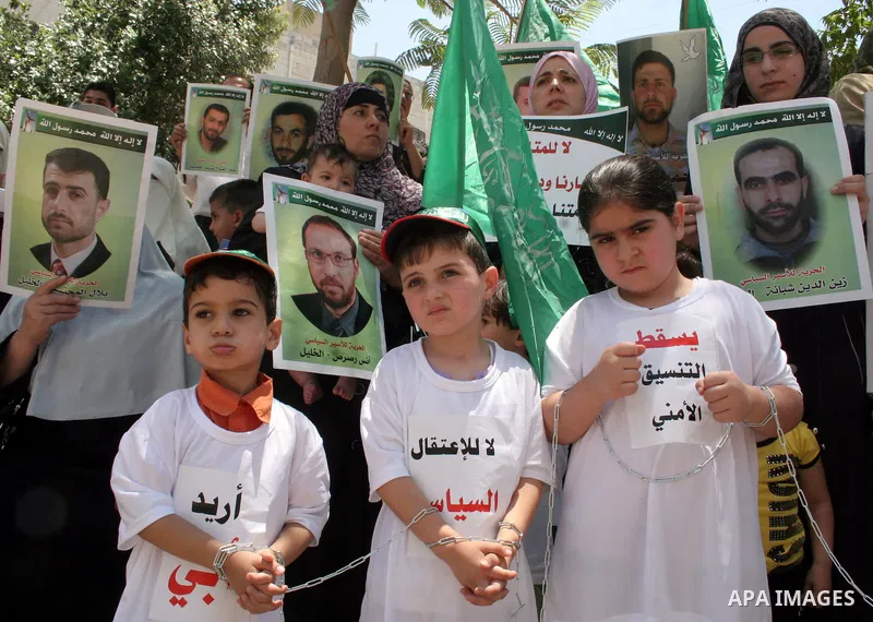Hamas members of the Palestinian Legislative Council (PLC) take part with Palestinian supporters of the Hamas Islamist movement during a rally calling for the release of Palestinians being held in West Bank and Gaza Stri...