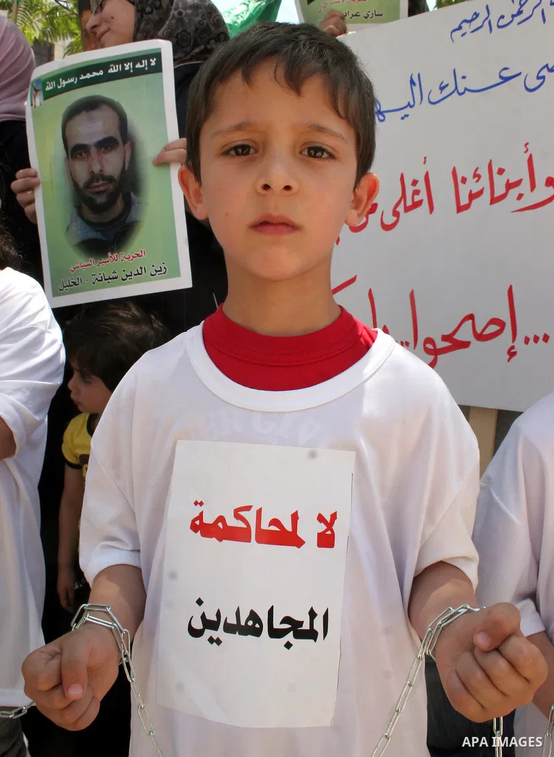 Hamas members of the Palestinian Legislative Council (PLC) take part with Palestinian supporters of the Hamas Islamist movement during a rally calling for the release of Palestinians being held in West Bank and Gaza Stri...