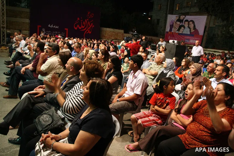 Palestinians watch as members of the band music, from the city of Akka, perform during the festival "Wayn ala Ramallah " in the West Bank city of Ramallah on July 14, 2011. Photo by Issam Rimawi