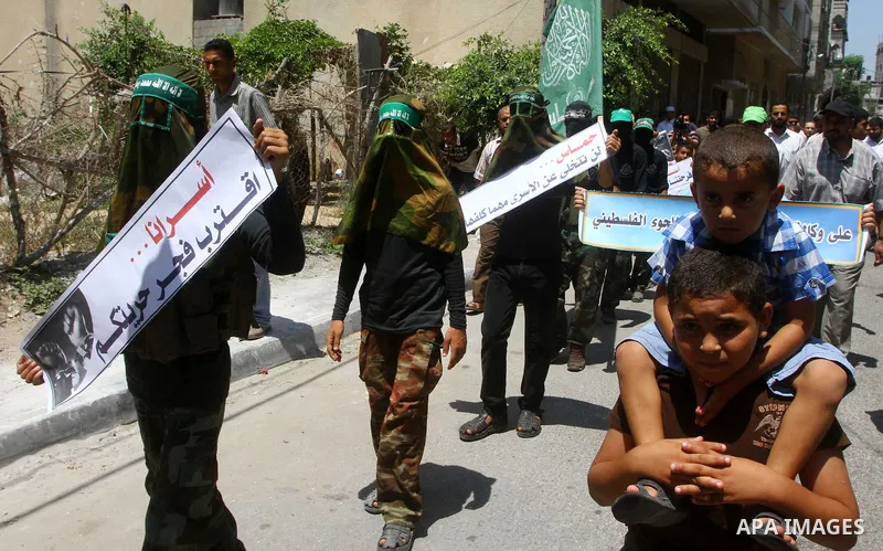 Masked Palestinians from Hamas participate in a protest calling for the release of Palestinian prisoners held in Israel and against the UNESCO decision to consider Jerusalem capital of Israel, at the Nusseirat refugee ca...