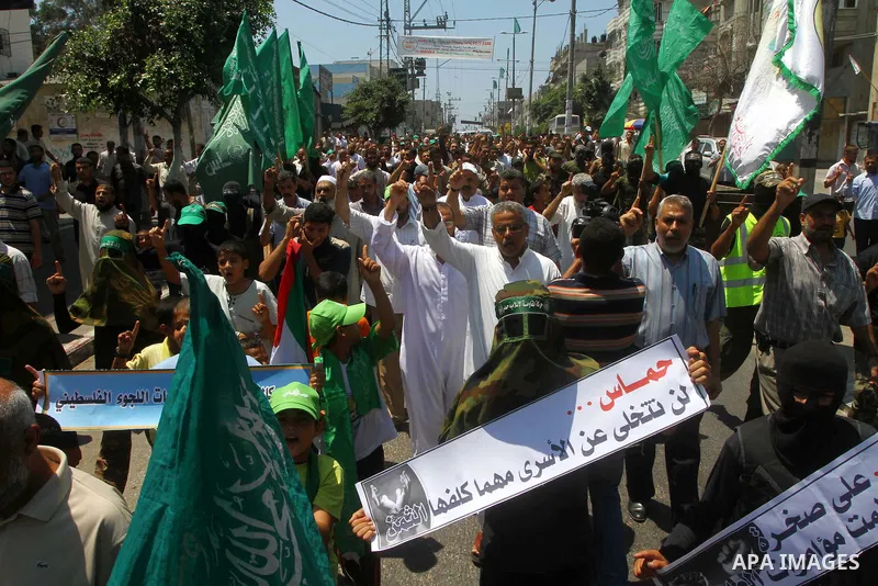 Palestinians Hamas supporters participate in a protest calling for the release of Palestinian prisoners held in Israel and against the UNESCO decision to consider Jerusalem capital of Israel, at the Nusseirat refugee cam...
