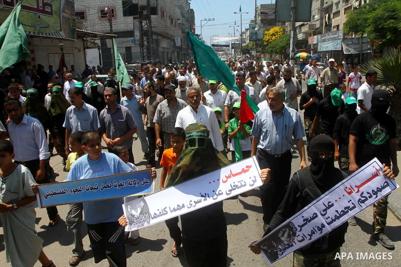 Palestinians Hamas supporters participate in a protest calling for the release of Palestinian prisoners held in Israel and against the UNESCO decision to consider Jerusalem capital of Israel, at the Nusseirat refugee cam...
