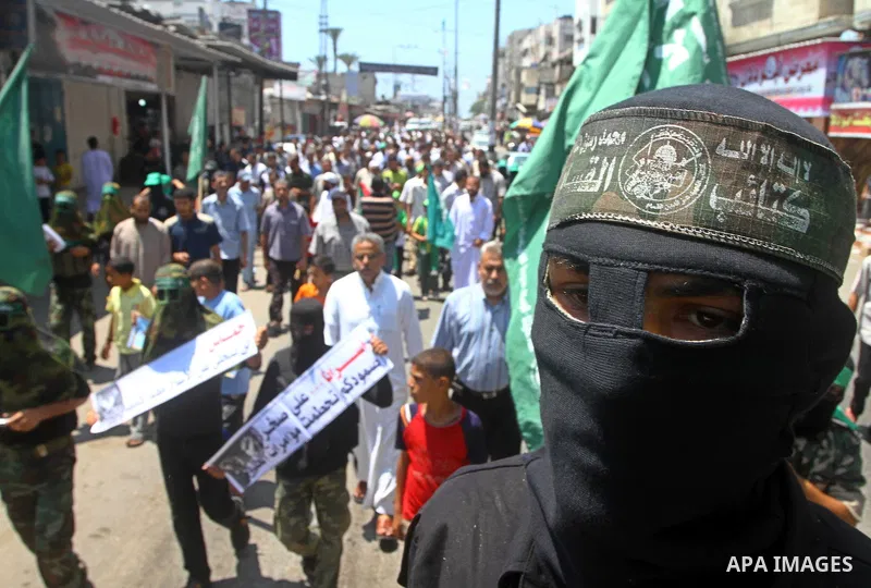 Masked Palestinians from Hamas participate in a protest calling for the release of Palestinian prisoners held in Israel and against the UNESCO decision to consider Jerusalem capital of Israel, at the Nusseirat refugee ca...