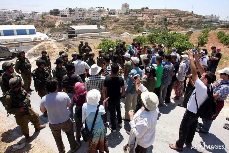 Protesters argue with an Israeli soldiers during a demonstration against Israel's controversial separation barrier in the West Bank village of Maasarah, near the biblical town of Bethlehem on 15 July 2011. Israel says th...