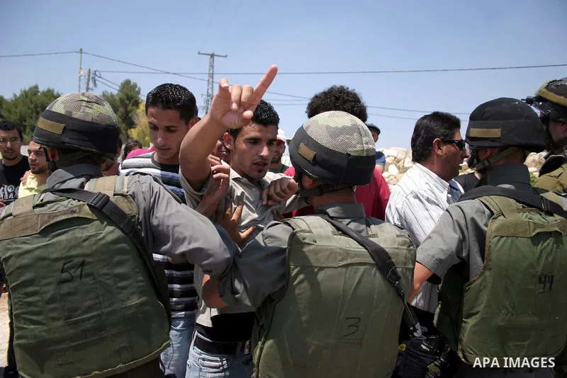 Protesters argue with an Israeli soldiers during a demonstration against Israel's controversial separation barrier in the West Bank village of Maasarah, near the biblical town of Bethlehem on 15 July 2011. Israel says th...