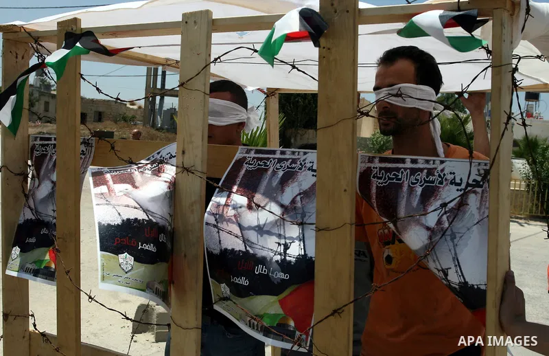 A Palestinian protesters look as prisoners participate in a demonstration against Israeli occupation and settlements expansion, on July 15, 2011 in the West Bank village of Nabi Saleh Photo by Issam Rimawi