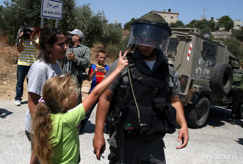 A Palestinian child argues with an Israeli soldier during clashes with protesters following a demonstration against Israeli occupation and settlements expansion, on July 15, 2011 in the West Bank village of Nabi Saleh Ph...