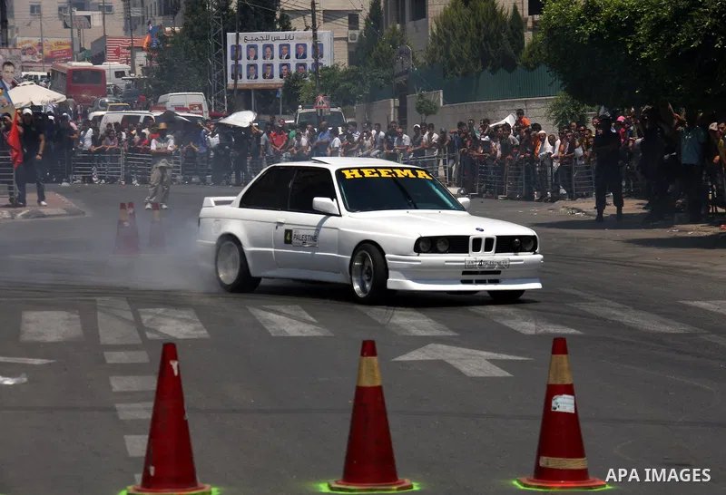 Palestinians watch cars race during the Palestinian National Racing Championship in the West Bank city of Nablus, Friday,July 15, 2011. Photo by Wagdi Eshtayah