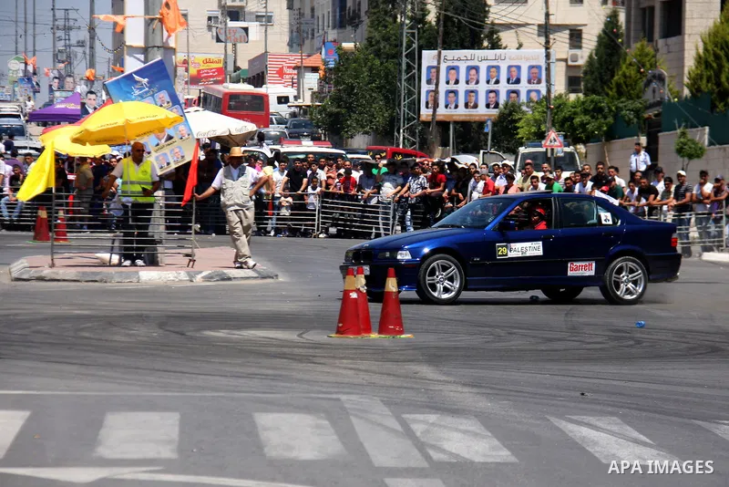 Palestinians watch cars race during the Palestinian National Racing Championship in the West Bank city of Nablus, Friday,July 15, 2011. Photo by Wagdi Eshtayah