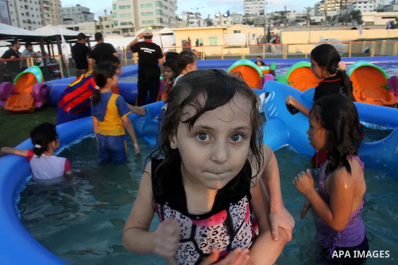Palestinian children play in a swimming pool at a park in Gaza City on July 15, 2011. Phot by Naaman Omar
