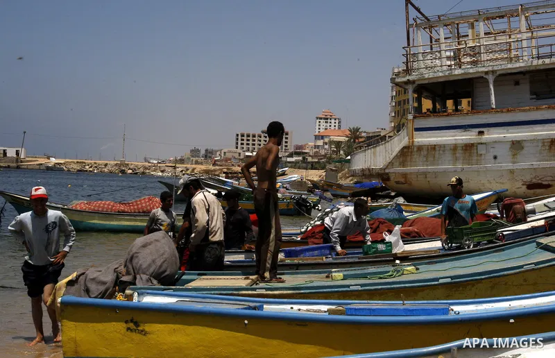 Palestinian fishermen prepare their boats for fishing at Gaza beach on July 16,2011. Photo by Mahmoud Nassar