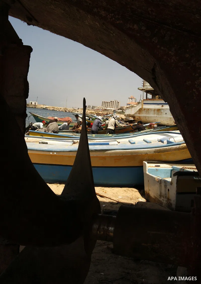 Palestinian fishermen prepare their boats for fishing at Gaza beach on July 16,2011. Photo by Mahmoud Nassar