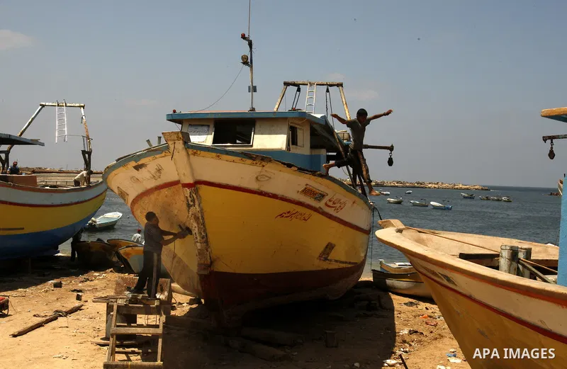 Palestinian fishermen prepare their boats for fishing at Gaza beach on July 16,2011. Photo by Mahmoud Nassar