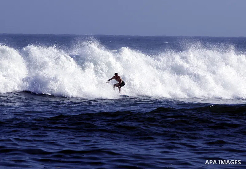 A Palestinian surfer rides a wave during a practise session in Gaza City on July 17, 2011 . Photo by Mahmud Nassar