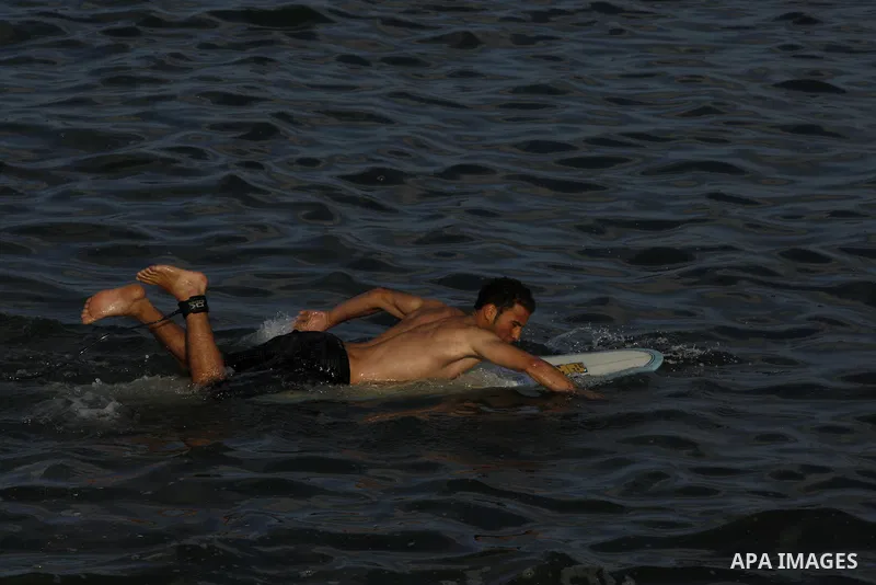 A Palestinian surfer rides a wave during a practise session in Gaza City on July 17, 2011 . Photo by Mahmud Nassar