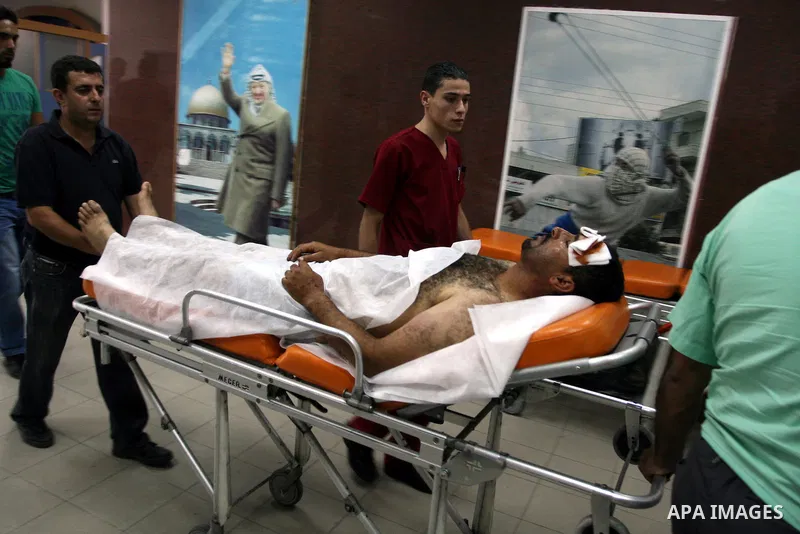 Palestinian medics wheel a man into a hospital in Ramallah on July 18, 2011 after he was, according to whiteness, attacked by Jewish settlers from the Migron outpost, while tending his sheep in the Palestinian village of...
