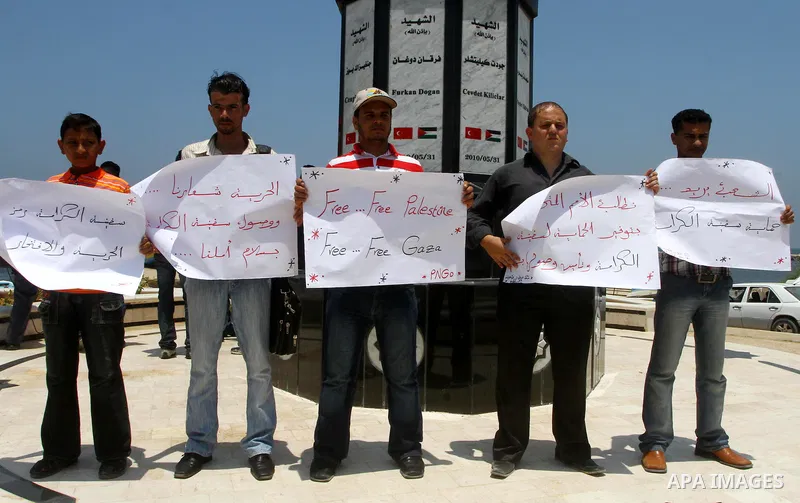 Palestinians hold banners at a protest at the Gaza seaport July 19, 2011. The Israeli navy on Tuesday boarded a French yacht carrying pro-Palestinian activists intending to sail to the blockaded Gaza Strip and forced it...