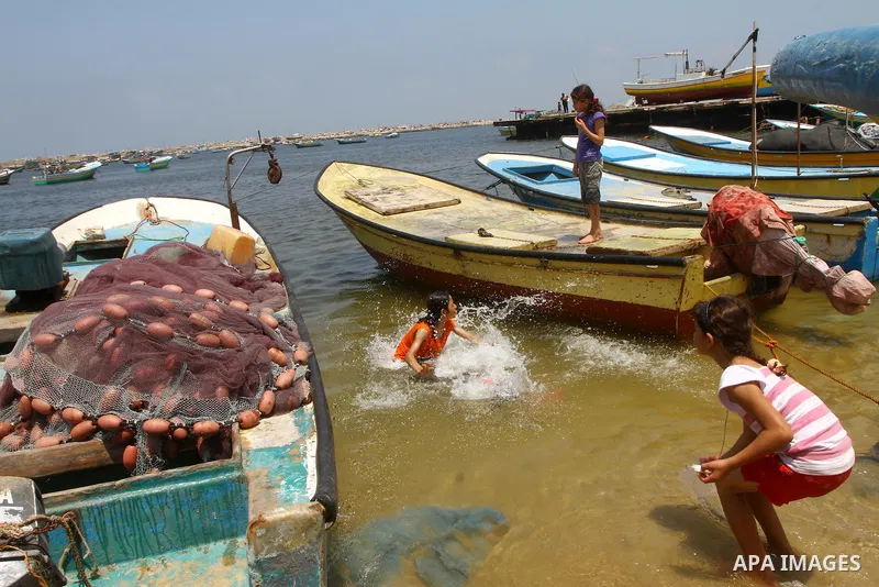 Palestinian children enjoy swimming in the Mediterranean sea at the port in Gaza City on July 19, 2011. Israel intercepted a French yacht heading for the Gaza Strip in defiance of its naval blockade, and began towing it...