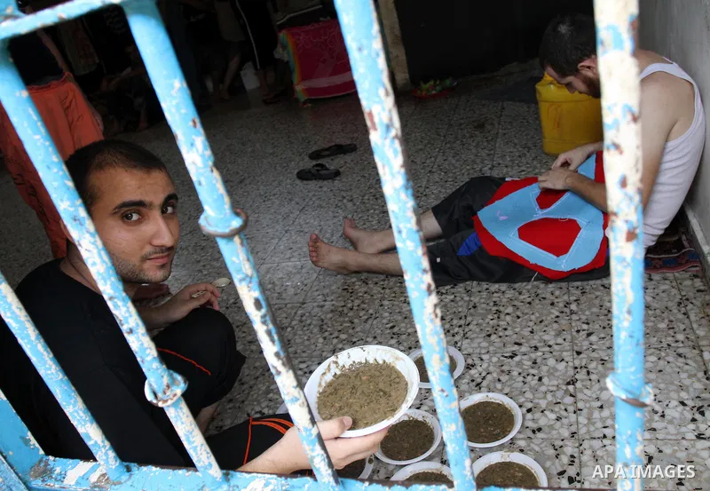 Palestinian inmates receive donated food from an Islamic charity at their cell in Gaza city on July 19,2011 . Photo by Mohammed Asad