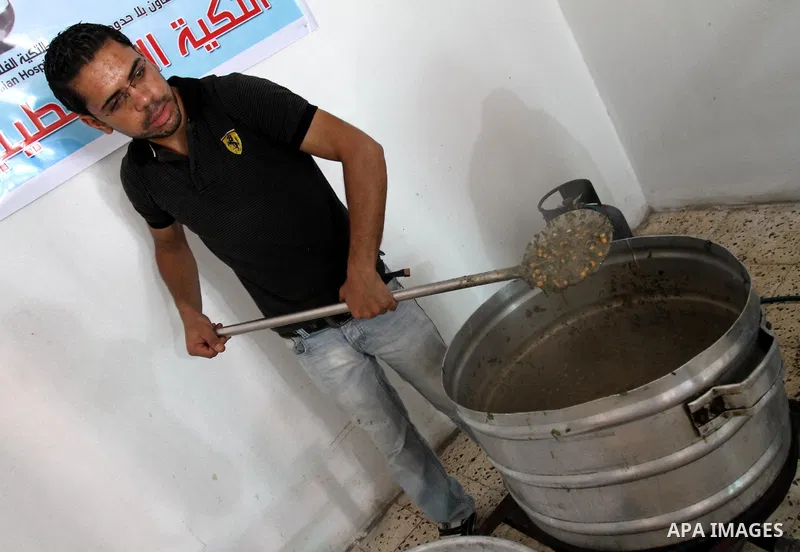 Palestinians receive donated food from an Islamic charity at a Palestinian hospice in Gaza city on July 19,2011. Photo by Mohammed Asad