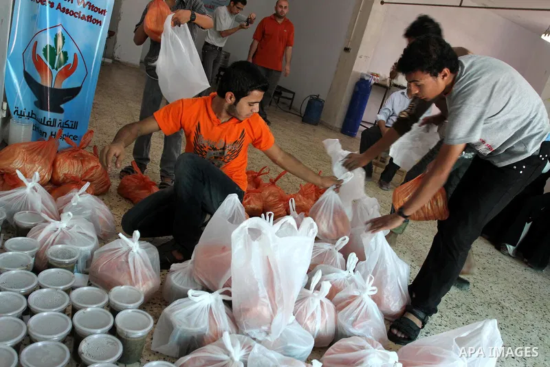 Palestinians receive donated food from an Islamic charity at a Palestinian hospice in Gaza city on July 19,2011. Photo by Mohammed Asad