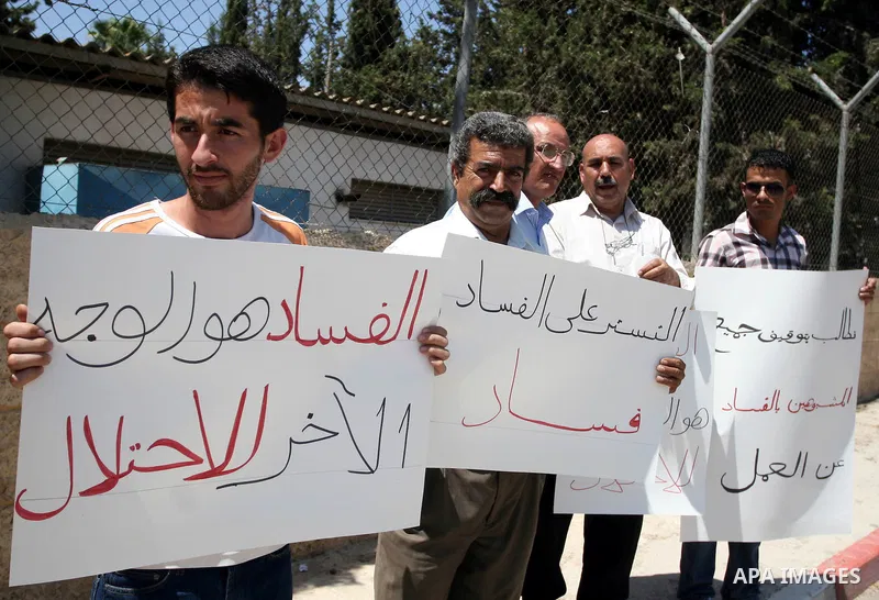 Palestinians take part in a protest outside the ministers council headquarters in the West Bank city of Ramallah on July 19, 2011, calling for the trial of ministers and officials accused of financial and administrative...