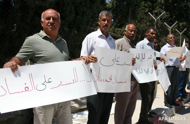 Palestinians take part in a protest outside the ministers council headquarters in the West Bank city of Ramallah on July 19, 2011, calling for the trial of ministers and officials accused of financial and administrative...