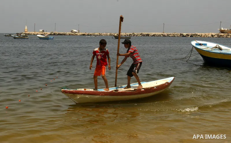 Palestinian children ride a boat at Gaza city port on July 19, 2011. Israeli naval commandos on Tuesday seized control of a French ship attempting to break Israel's blockade of the Gaza Strip, reporting no resistance dur...