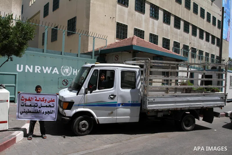 A Palestinian boy holds banner during closing the gates of the UNRWA headquarters in Gaza against the UNRWA decision to change its name in Gaza city on July 20, 2011. .Photo by Mohammed Asad