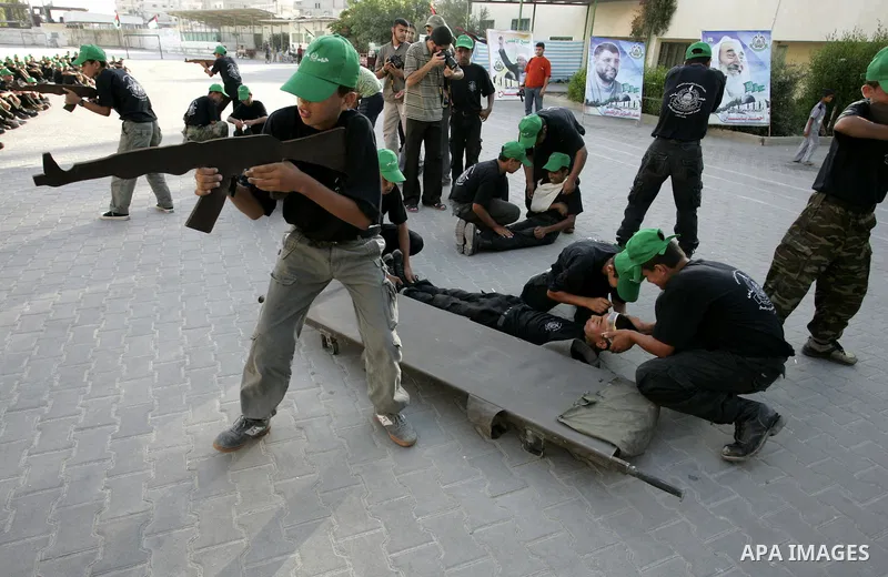 Palestinian youths parade with wooden weapons at a Hamas-run summer camp in Rafah, southern Gaza Strip, on July 20, 2011. The Islamist movement Hamas is holding summer camps throughout the Gaza Strip, where participants...
