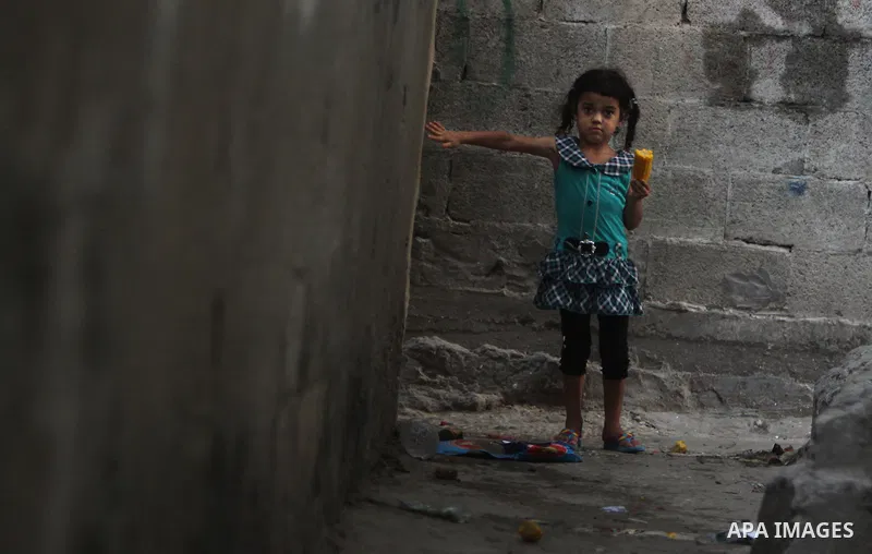 A Palestinian girl plays in front of her house in Jabaliya refugee camp in the northern area of the Gaza Strip on July 21, 2011. The UN Relief and Works Agency (UNRWA) will reduce some of its services for Palestinian ref...