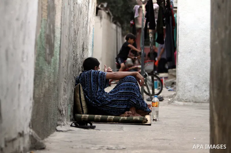 A Palestinian boy sits in front of her house in Jabaliya refugee camp in the northern area of the Gaza Strip on July 21, 2011. The UN Relief and Works Agency (UNRWA) will reduce some of its services for Palestinian refug...