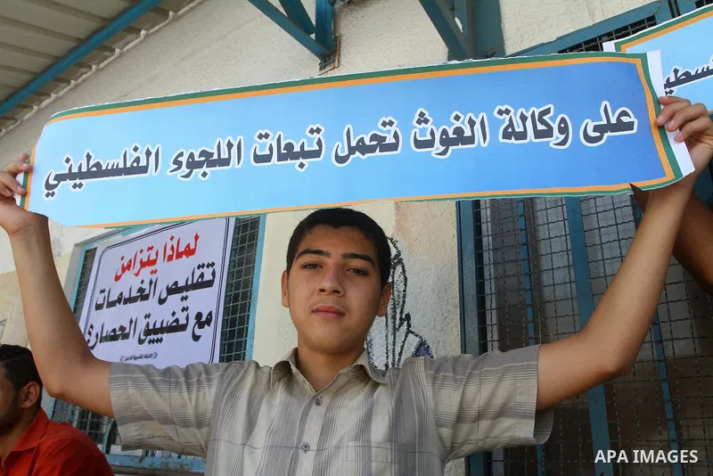 A Palestinian boy holds banner during a protest infront of the UNRWA headquarters against the UNRWA decision to change its name and Reduce aid in Gaza city on July 21, 2011. Photo by Ashraf Amra