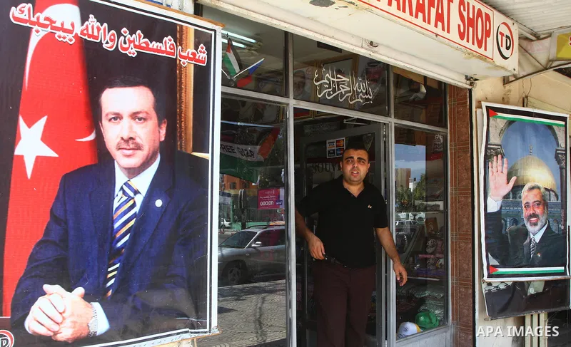 A Palestinian vendor displays pictures of Turkish Prime Minister Recep Tayyip Erdogan and of Hamas leader, Ismail Haniyeh, outside his shop in Gaza City on July 21, 2011 following Erdogan's statement that he was consider...