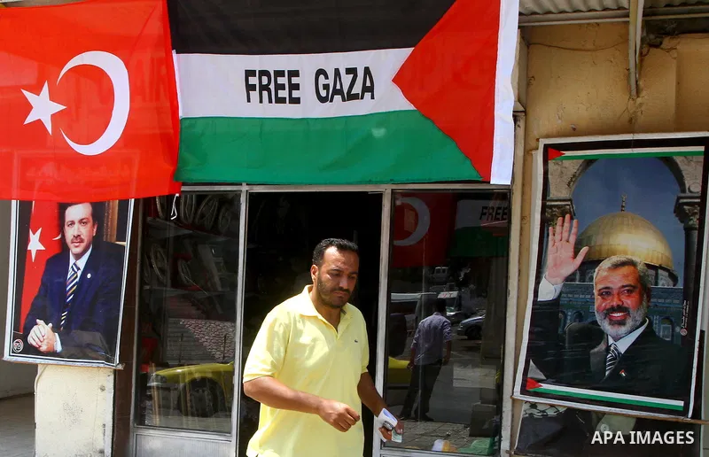 A Palestinian vendor displays pictures of Turkish Prime Minister Recep Tayyip Erdogan and of Hamas leader, Ismail Haniyeh, outside his shop in Gaza City on July 21, 2011 following Erdogan's statement that he was consider...