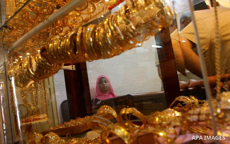 A Palestinian woman looks at gold jewellery at a jewellery store in Gaza city on 21 July 2011. A Palestinian vendor says that the one gold ounce cost 1650 US dollars at the local market which is and all time high for the...