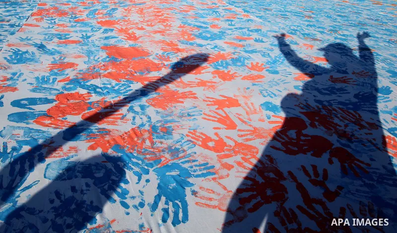 Palestinian children attend an event organised by the the United Nations Relief and Works Agency (UNRWA) in which they attempt to break the Guinness world record for the largest hand-print paint in Khan Yunis, southern G...