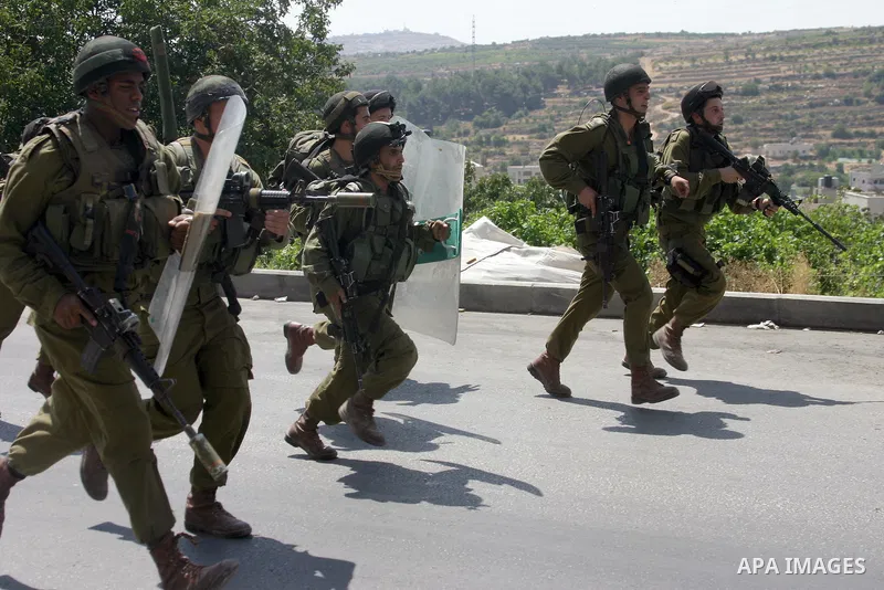 Israeli soldiers take position during a demonstration by Palestinian, Israeli, and foreign protesters in the West Bank village of Beit Omar, near Hebron Friday, July 22, 2011. The demonstration concerned a recent video r...